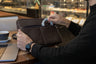 Coffee Nordweg Workplace leather laptop sleeve with a cable in the front pocket at a cafe