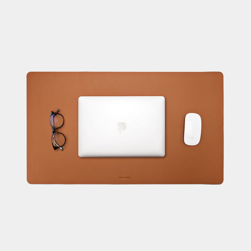 Nordweg Workplace leather desk pad in caramel with laptop, mouse, and glasses