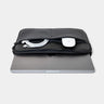 Black Workplace leather laptop sleeve case front pocket detail with cable and white accessory