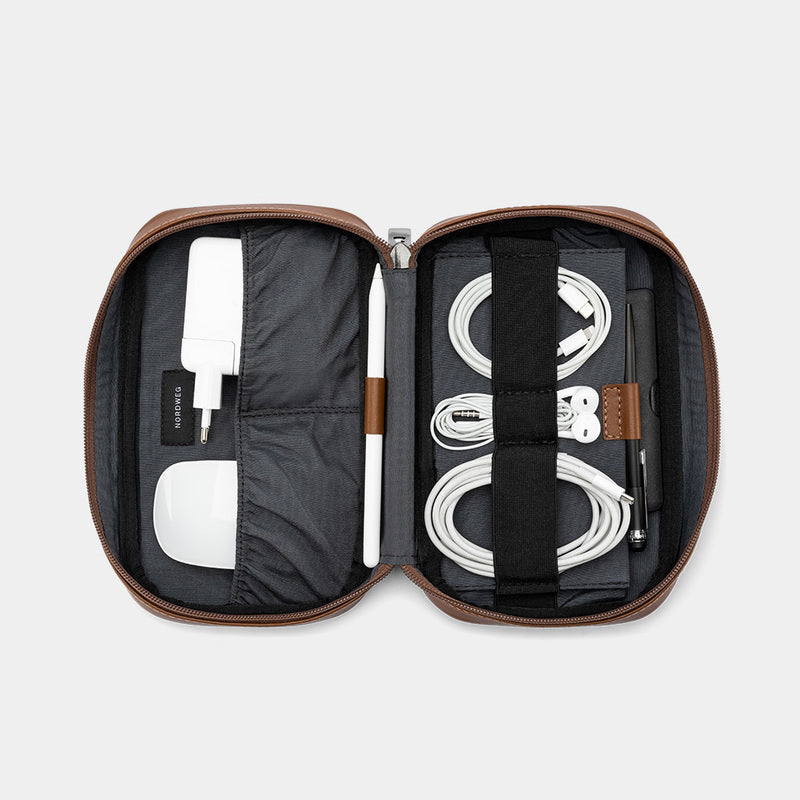 Open caramel Nordweg Workplace leather tech organizer with cables, charger, and earbuds case