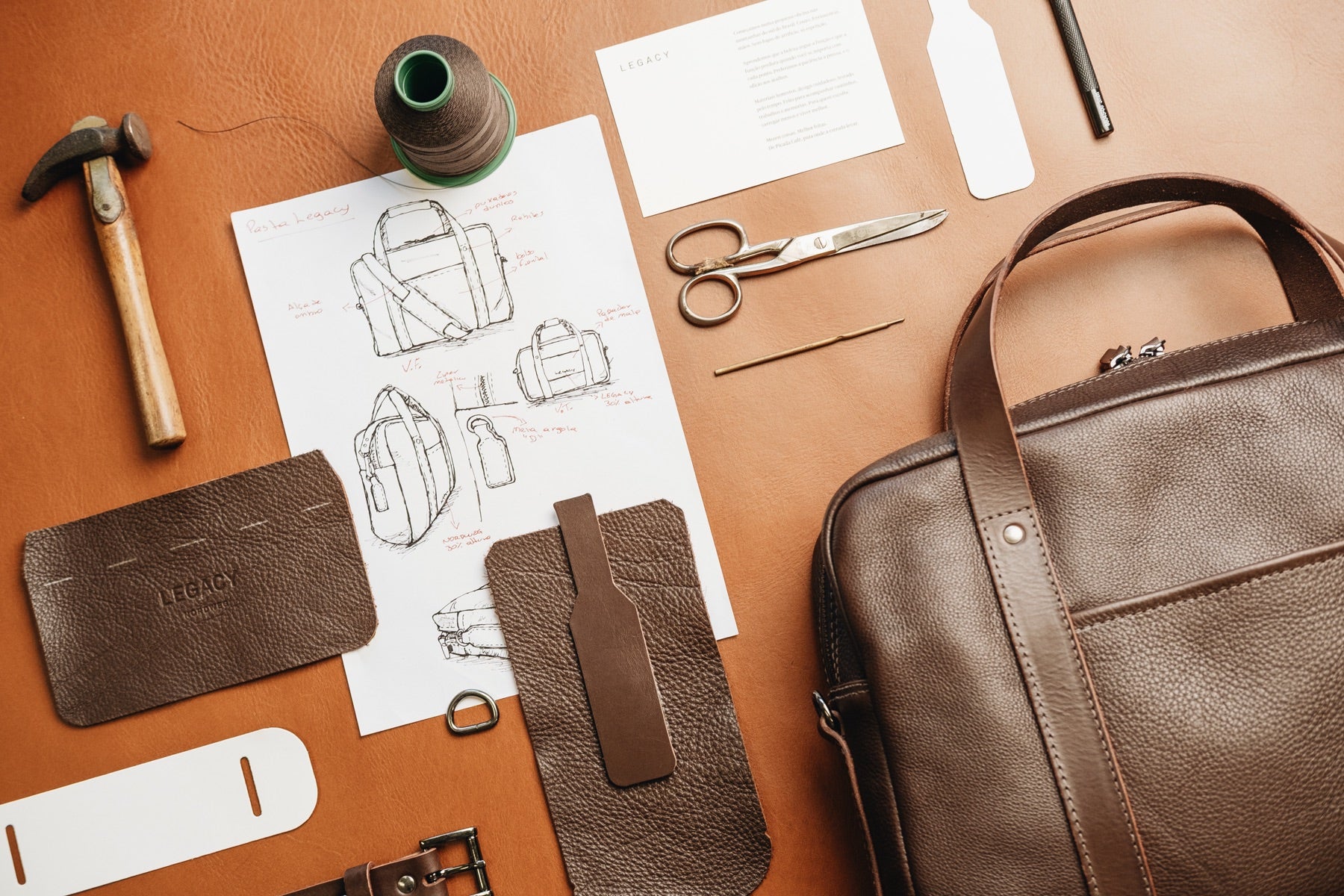 Legacy materials and design sketches on a leather workbench