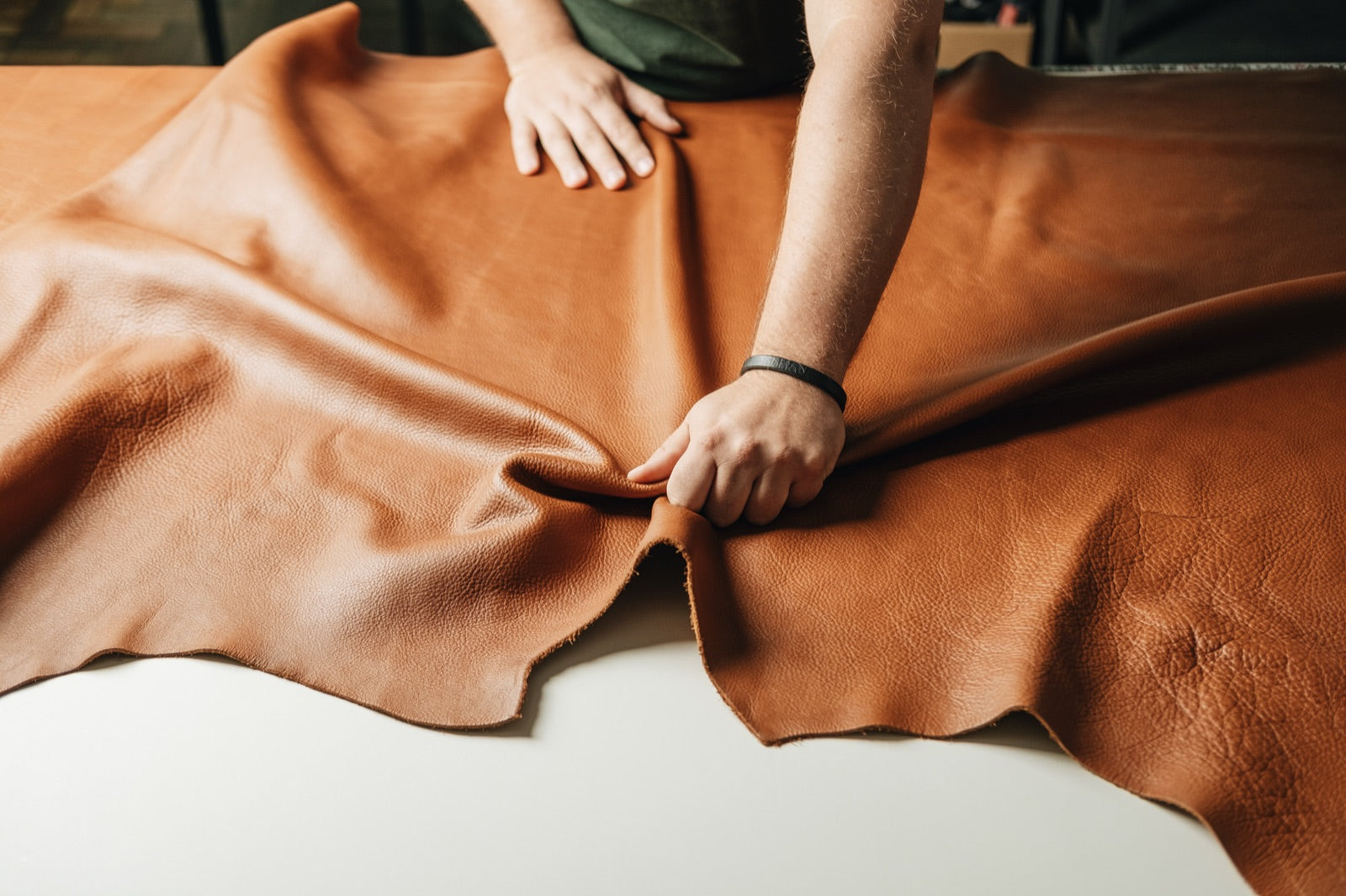 Full-grain floater leather being handled in the workshop