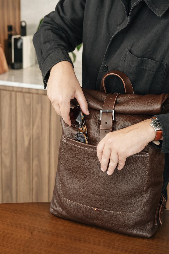 Espresso Legacy Backpack front pocket being opened to put away glasses