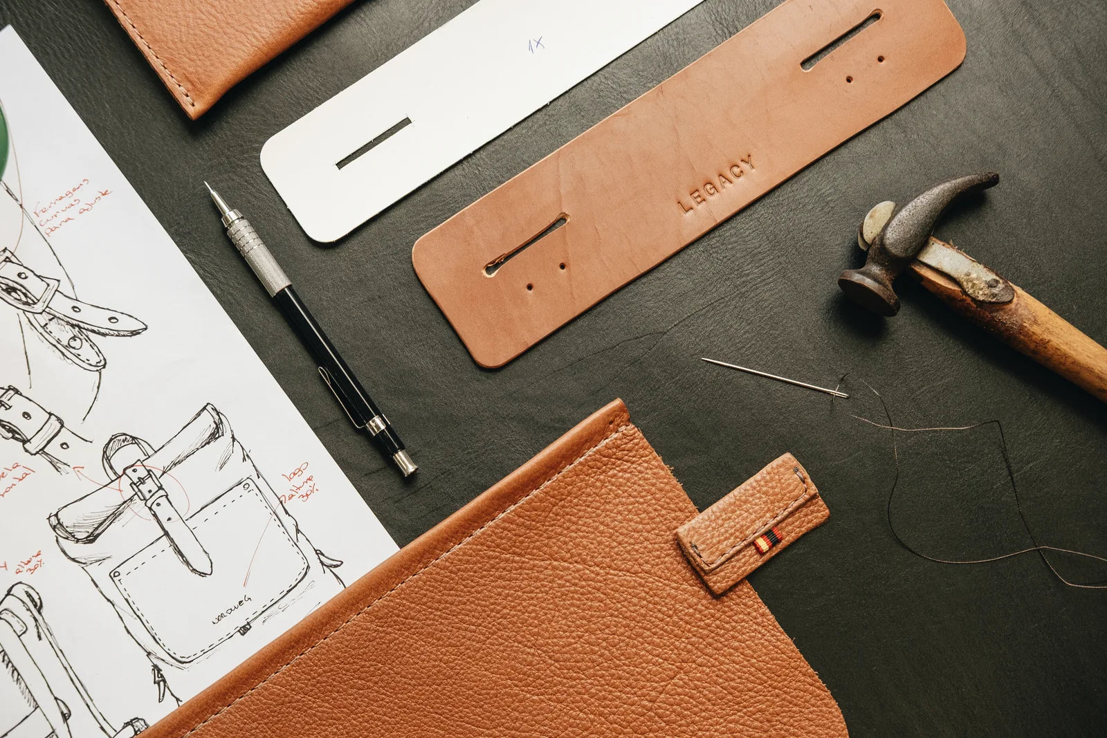 Drawings and cut leather components on the workshop table