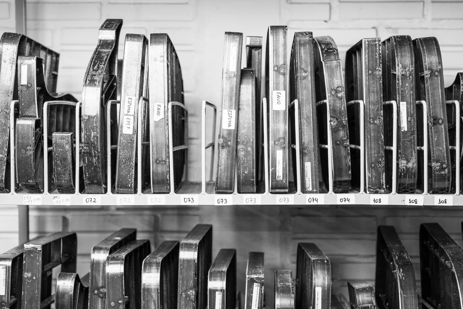 Rows of metal cutting dies stored on workshop shelves