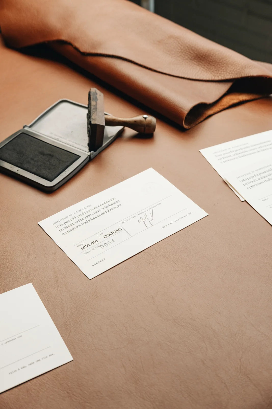 Workshop stamps and printed cards laid out beside a leather hide