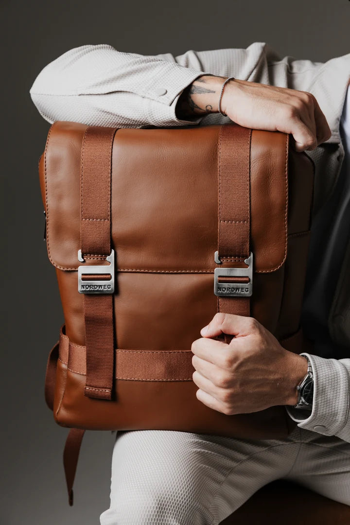 Caramel Dolomites travel backpack held to show its front buckles