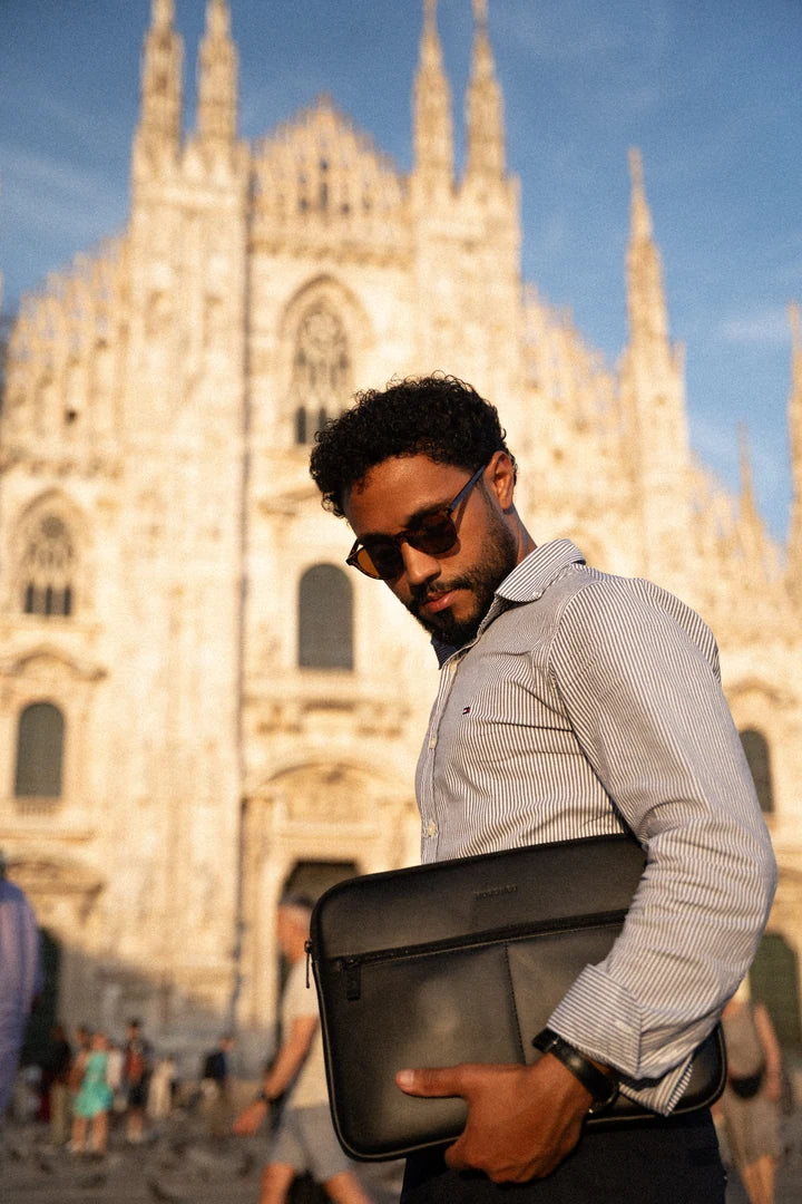 Black Workplace laptop sleeve carried in warm sunlight in Milan