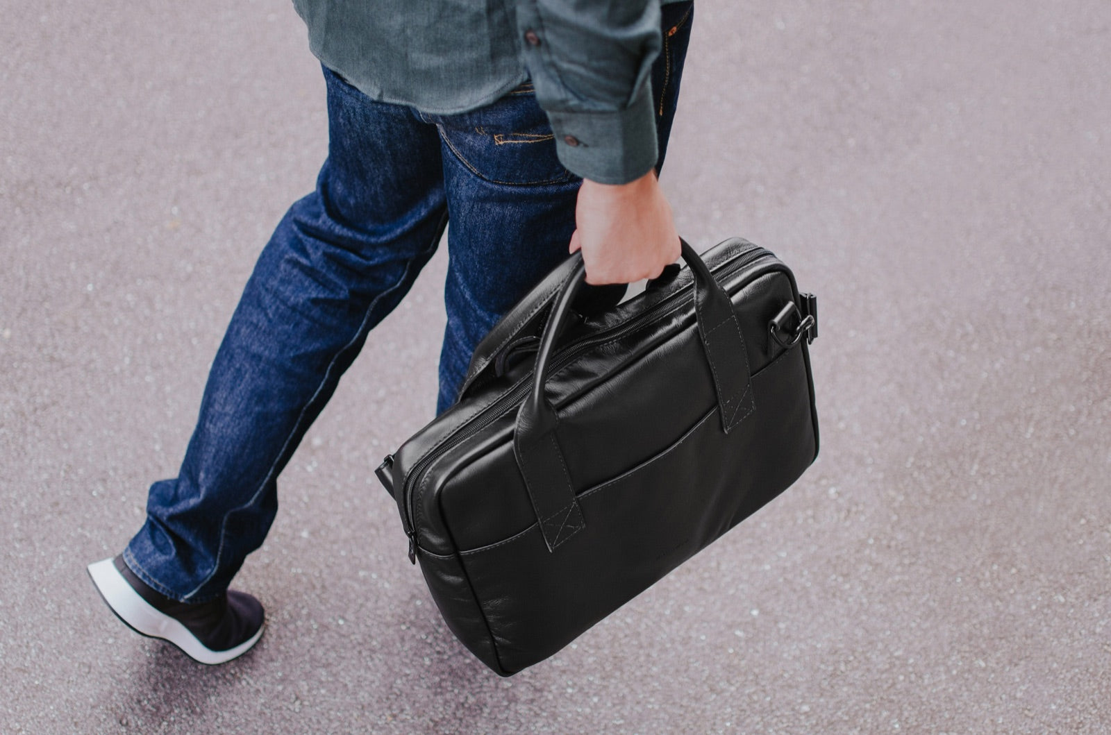 Black Nomad leather briefcase carried through the city